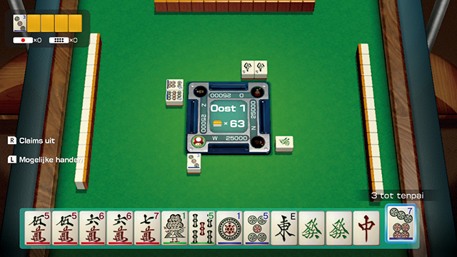 Jeu de Mahjong en cours. Les tuiles sont disposées sur une table verte.