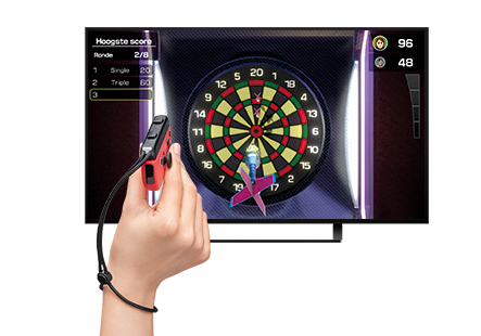 Une personne jouant aux fléchettes sur un écran de télévision. Une manette de jeu rouge est dans la main.
