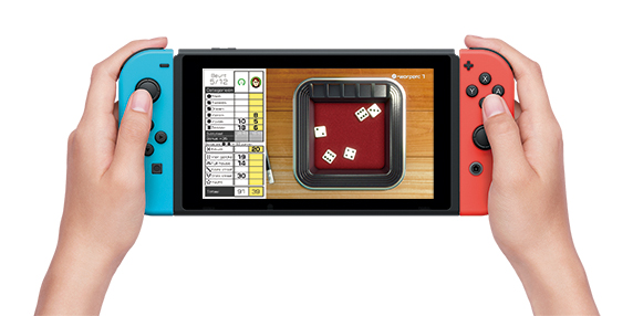 Mains tenant une Nintendo Switch. Jeu à l'écran avec un jeu de dés. Manettes bleues et rouges.