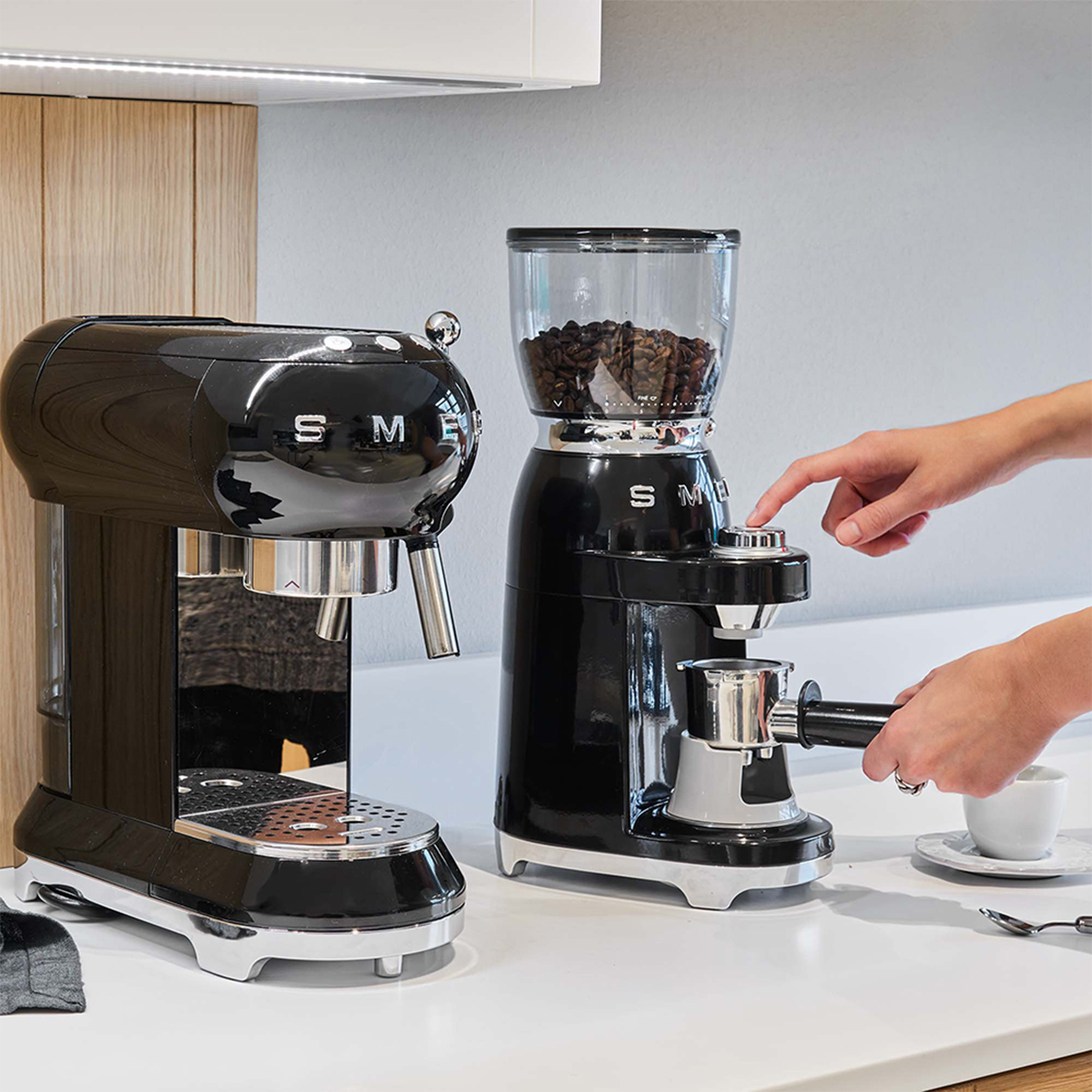Due macchine da caffè SMEG nere. Una è una macchina per espresso e l'altra è un macinacaffè.
