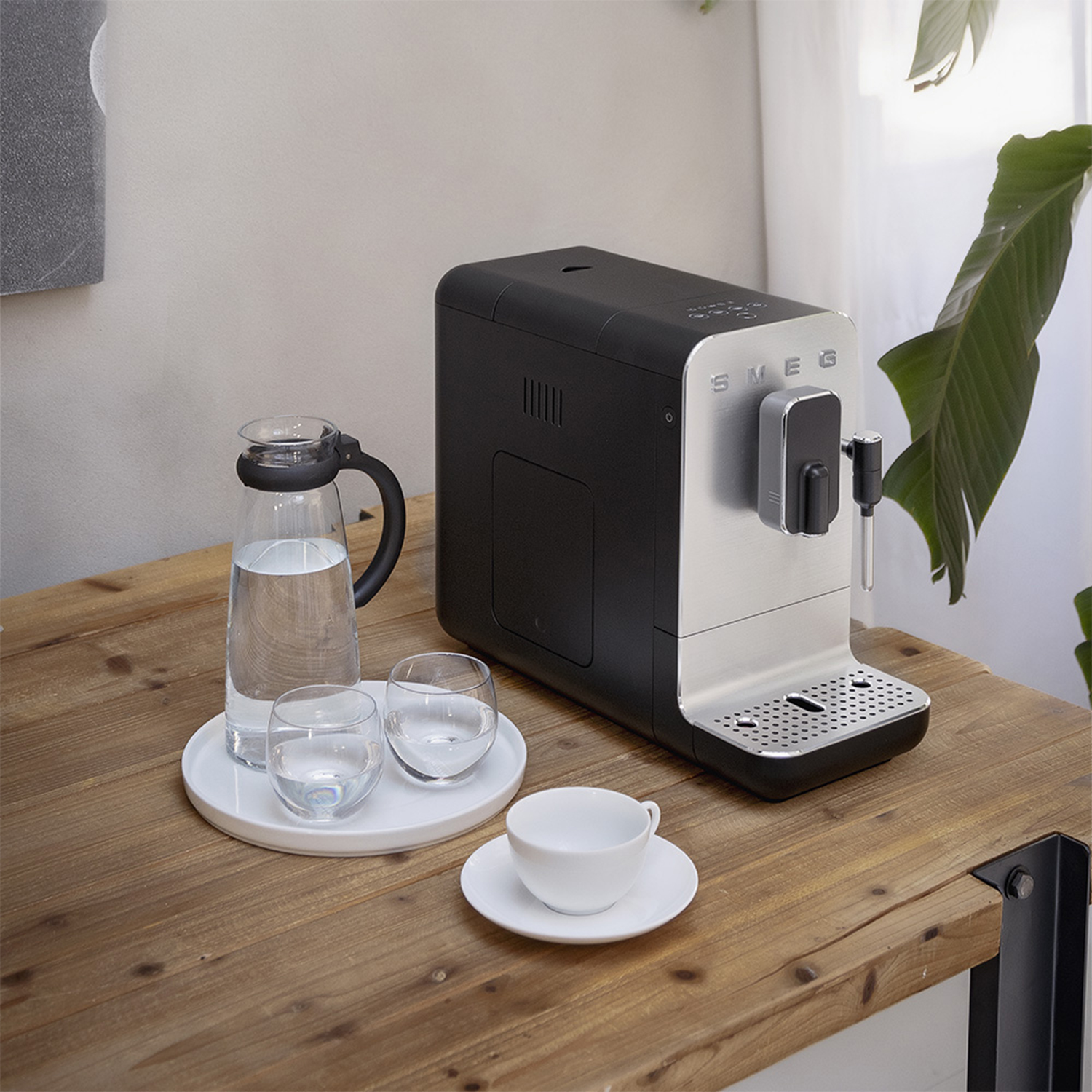Macchina per caffè espresso con brocca, bicchieri e tazza.