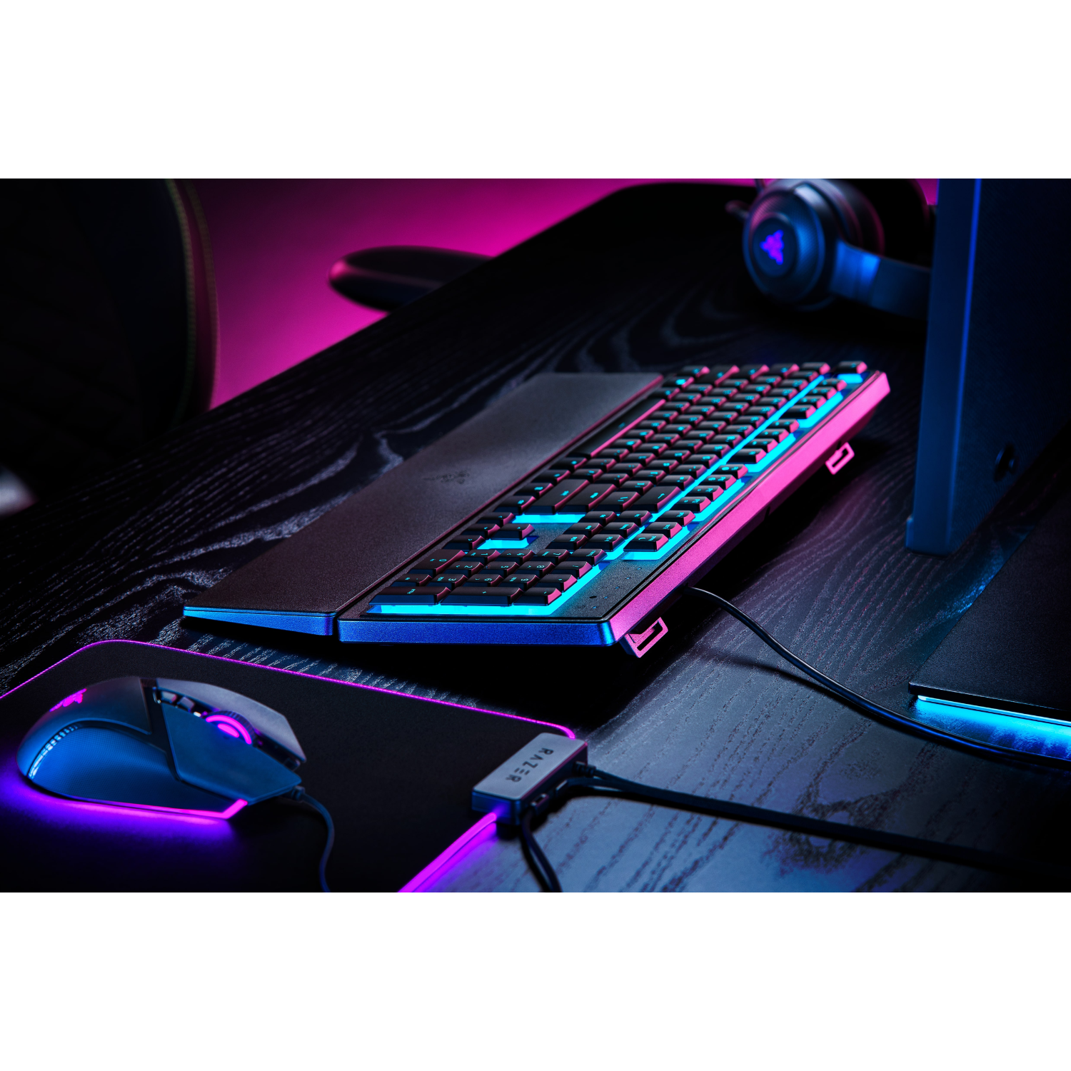 Gaming-opstelling met toetsenbord, muis en koptelefoon. Toetsenbord heeft gekleurde lichten.