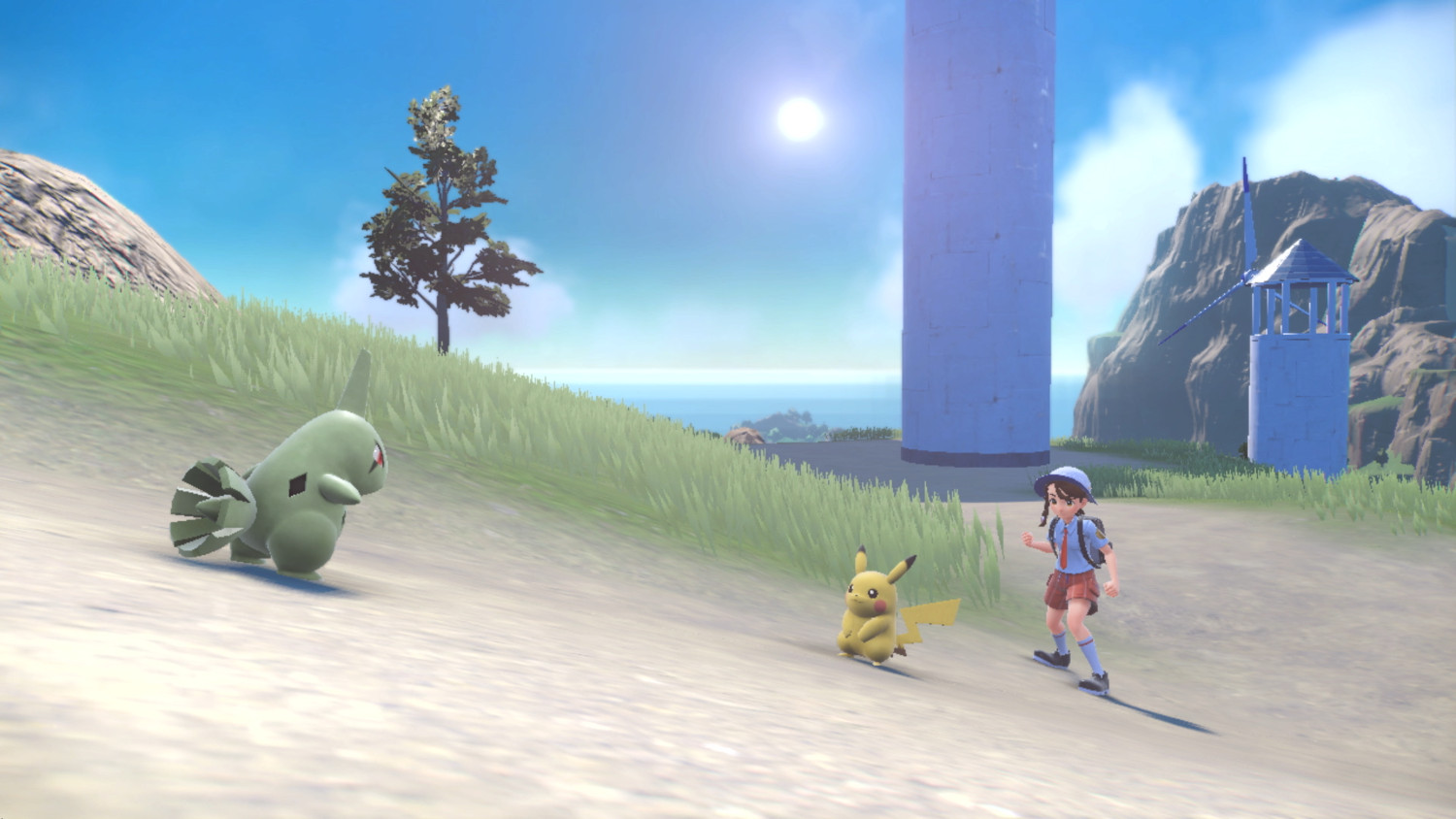 Pokemon scène met een groen wezen, Pikachu en een trainer op een zonnige heuvel met vuurtoren op de achtergrond.