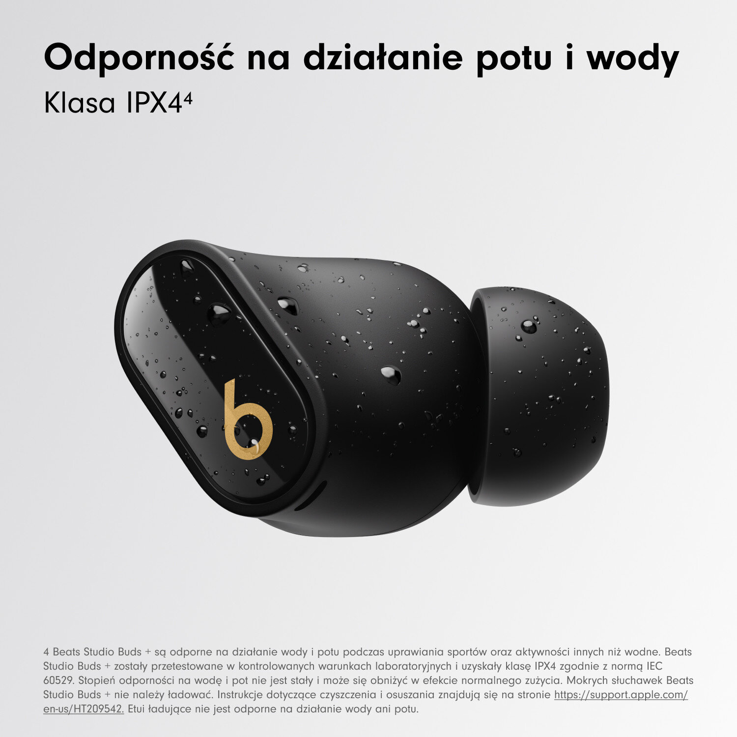 Czarne Beats Studio Buds z kroplami wody, białym tekstem i złotym logo 'b'.