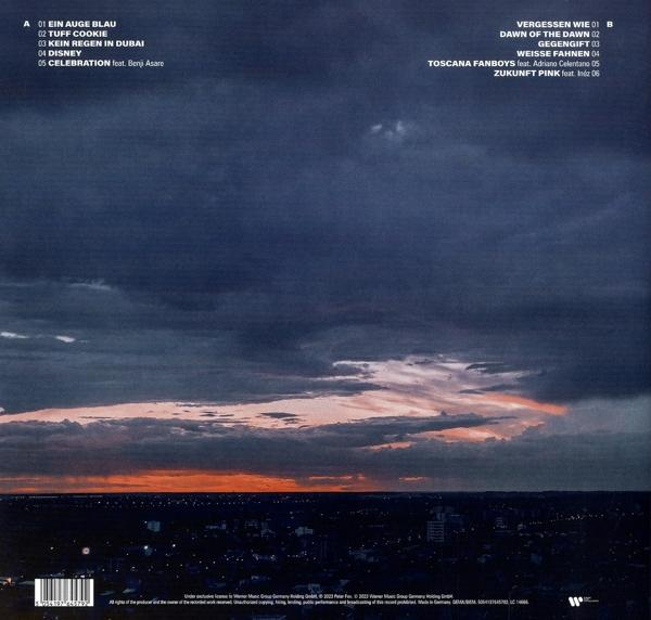 Sonnenuntergang über einer Stadt mit dunklen Wolken und einem leuchtend orangefarbenen Himmel.