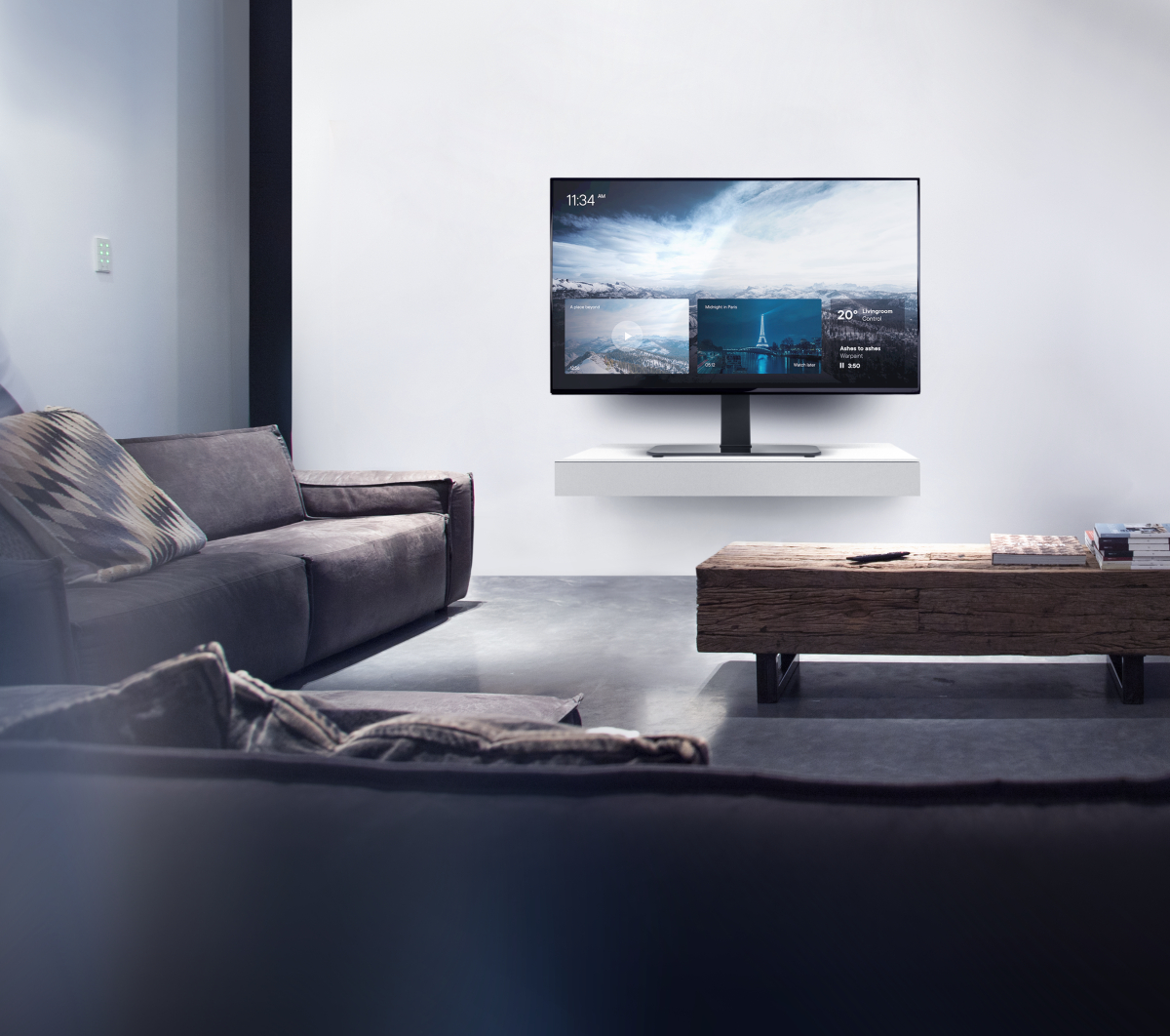 Wohnzimmer mit Sofa, Fernseher an der Wand und Couchtisch.