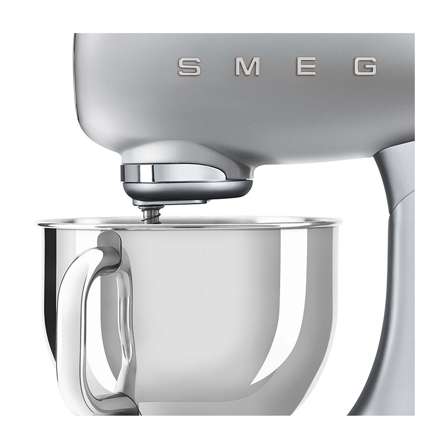 Un'impastatrice argentata, primo piano che mostra la parte superiore e la ciotola. Il marchio SMEG è visibile.