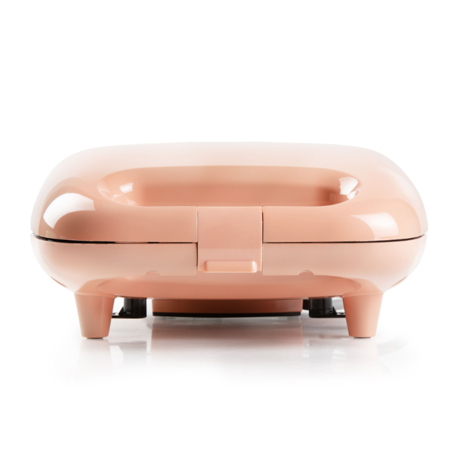 Gaufrier rose sur une surface blanche. Le gaufrier est fermé et possède une poignée.
