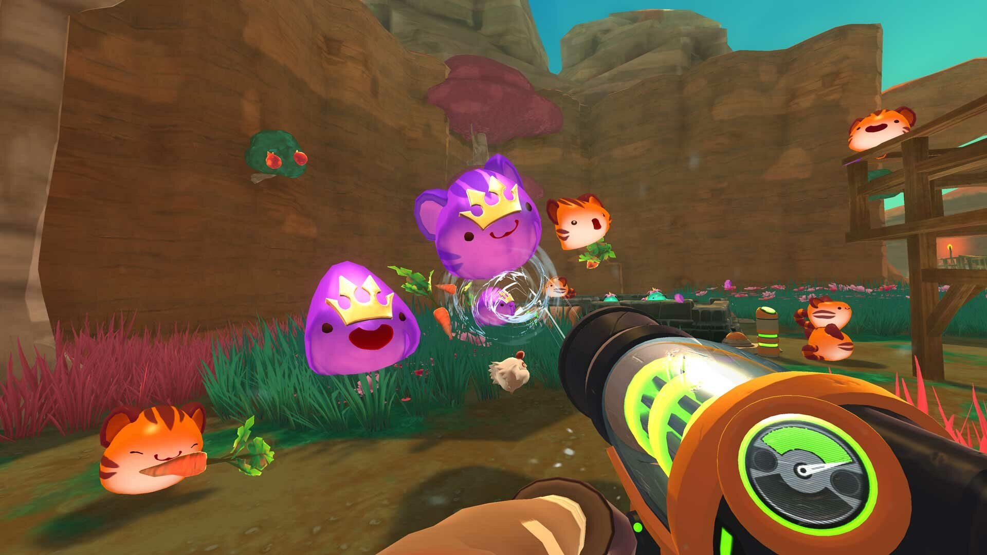 Scena z gry Slime Rancher. Slime, broń na pierwszym planie, kolorowe tło.