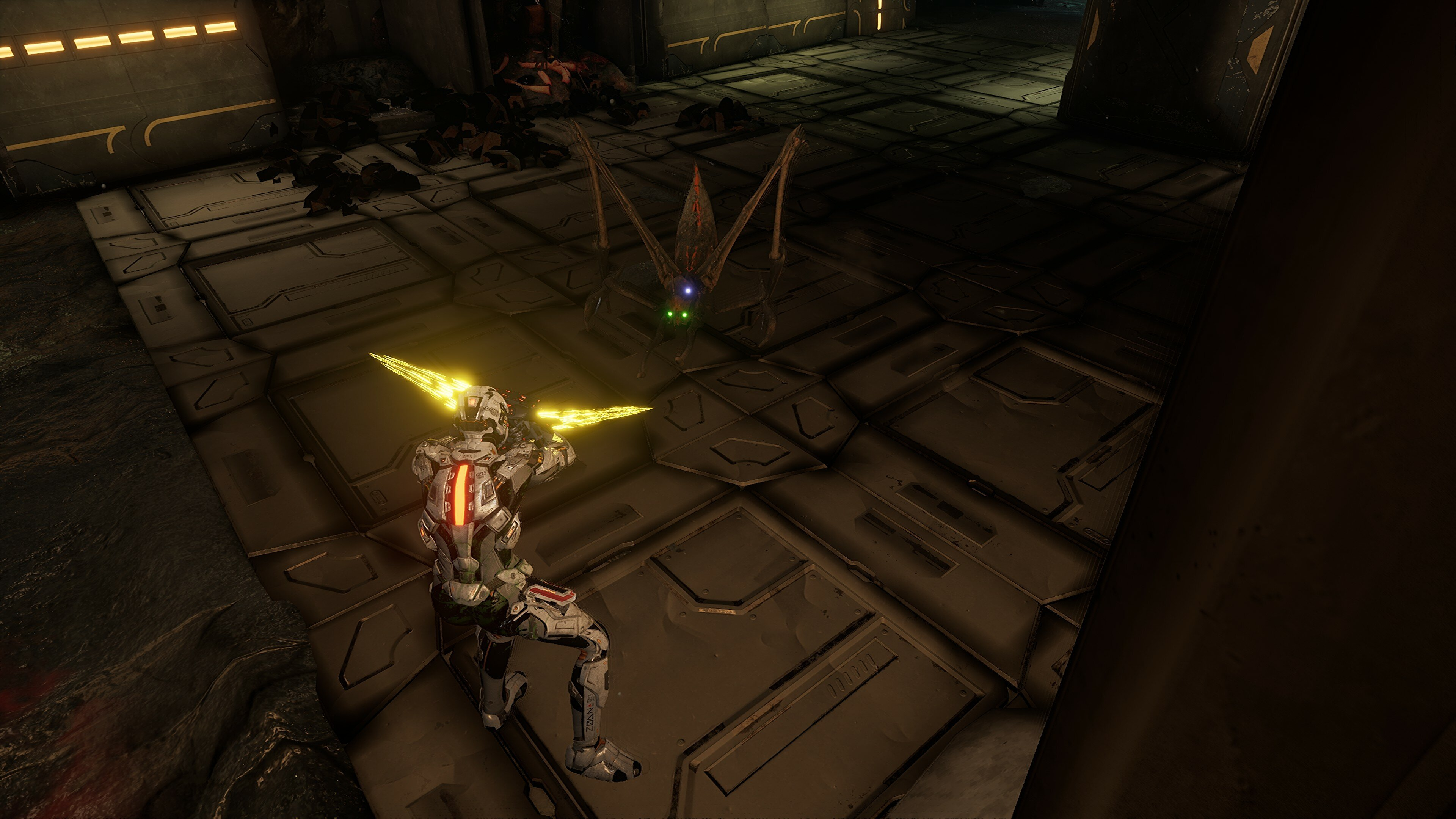 Scena z gry wideo: żołnierz walczy z podobnym do owada stworzeniem w ciemnym otoczeniu.