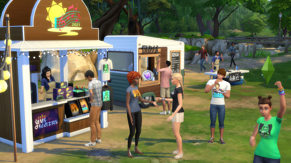 Scena z letniego festiwalu z ludźmi, straganami, food truckiem i sceną z transparentem.