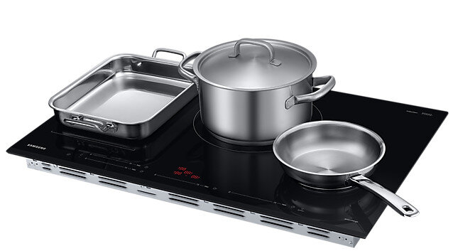 Czarna płyta indukcyjna Samsung ze stalowymi patelniami. Widoczny garnek, patelnia i brytfanna.