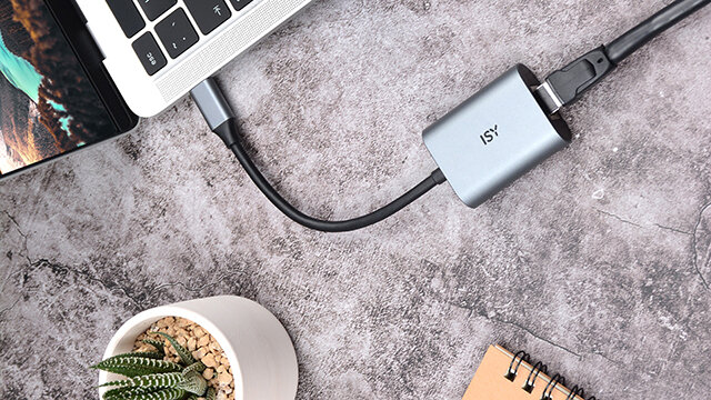 Laptop podłączony do huba, z kablem ethernet i adapterem USB.