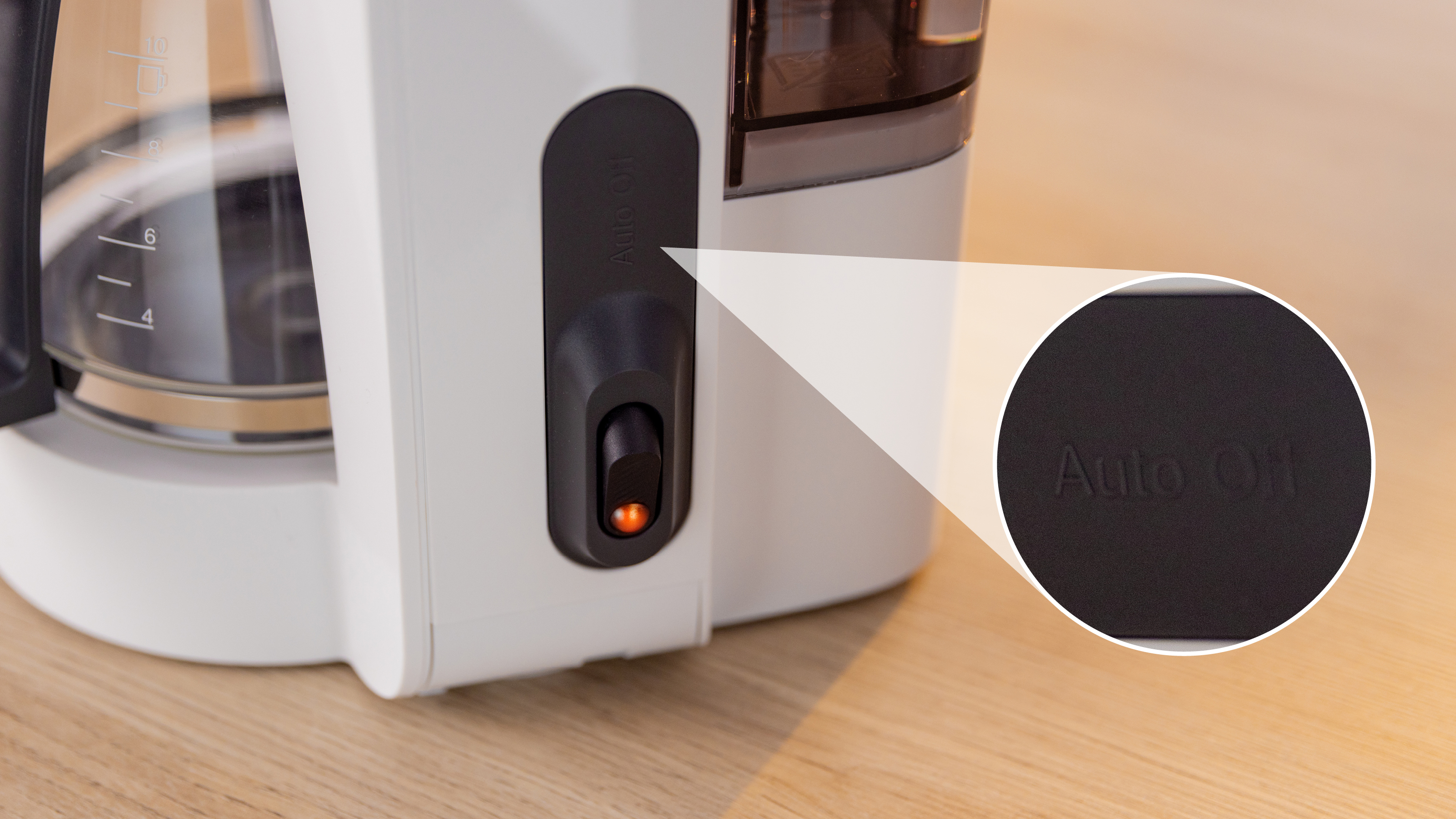 Nahaufnahme einer Kaffeemaschine mit hervorgehobener 'Auto Off'-Taste, die das Schalterdetail zeigt.