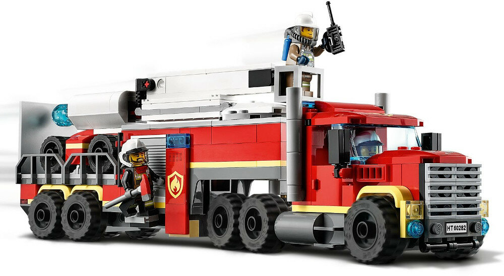 Czerwony wóz strażacki Lego z dwoma strażakami i drabiną na białym tle.
