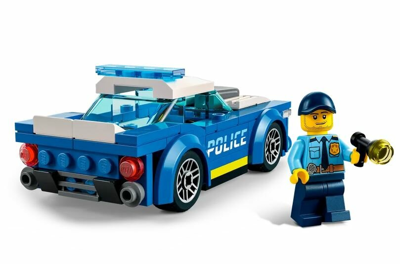 Zabawka Lego samochód policyjny z policjantem trzymającym latarkę.