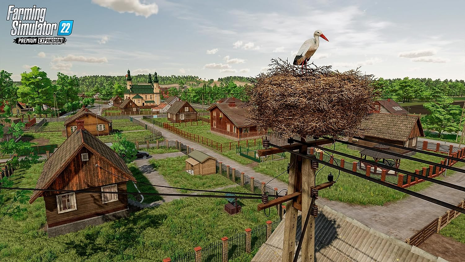 Escena de Farming Simulator 22. Un pueblo con un nido de cigüeñas en un poste eléctrico.