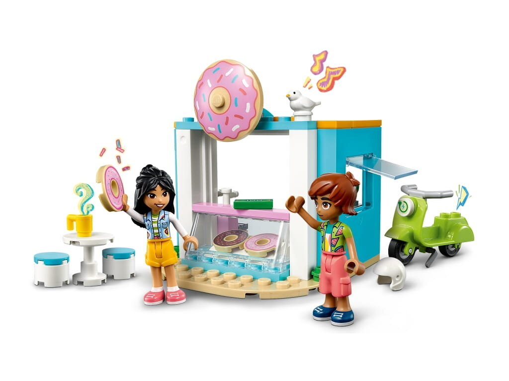 Dwie figurki Lego w sklepie z pączkami ze skuterem.