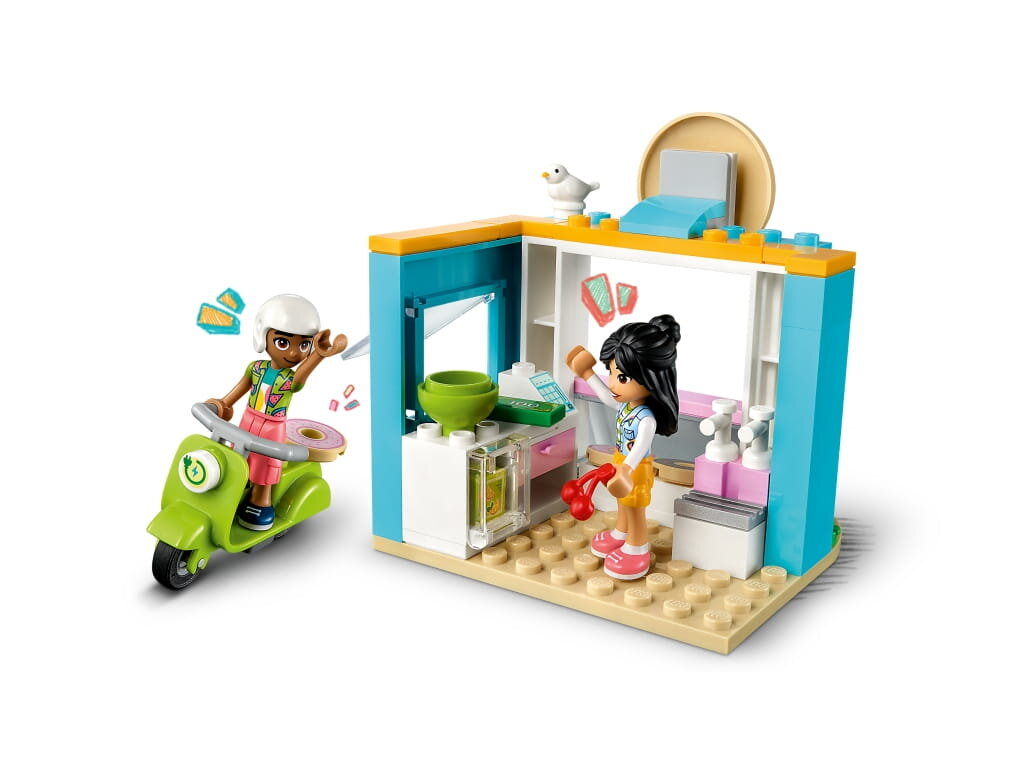 Scena Lego: Dwie figurki w pobliżu sklepu, jedna na skuterze, druga w środku obsługuje klientów.
