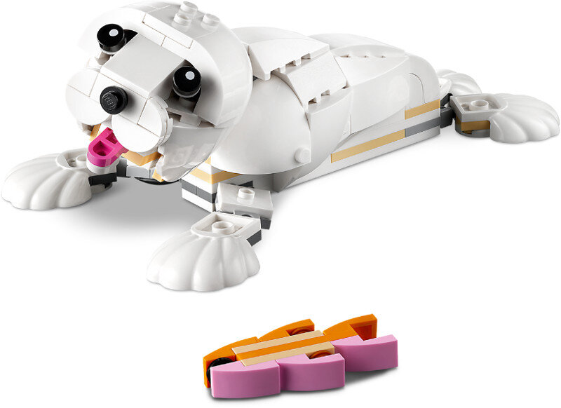 Zabawka Lego w kształcie foki z różowym językiem i małą pomarańczową i różową zabawką przed nią.