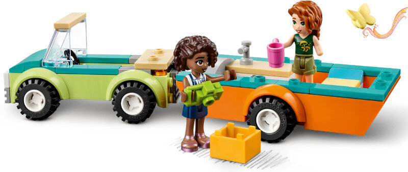 Zestaw Lego Friends. Dwie postacie w pobliżu kolorowego pojazdu. Motyl leci w tle.