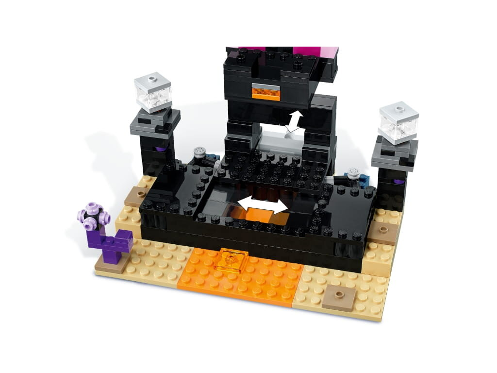 Zestaw Lego Minecraft przedstawia czarną konstrukcję z pomarańczowymi i fioletowymi detalami na beżowej podstawie.
