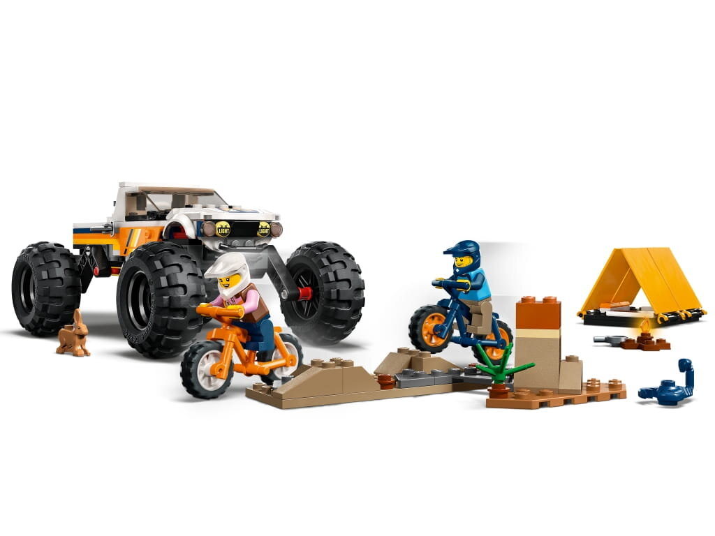 Scena Lego: monster truck, motocykle na rampach, namiot i figurka królika.
