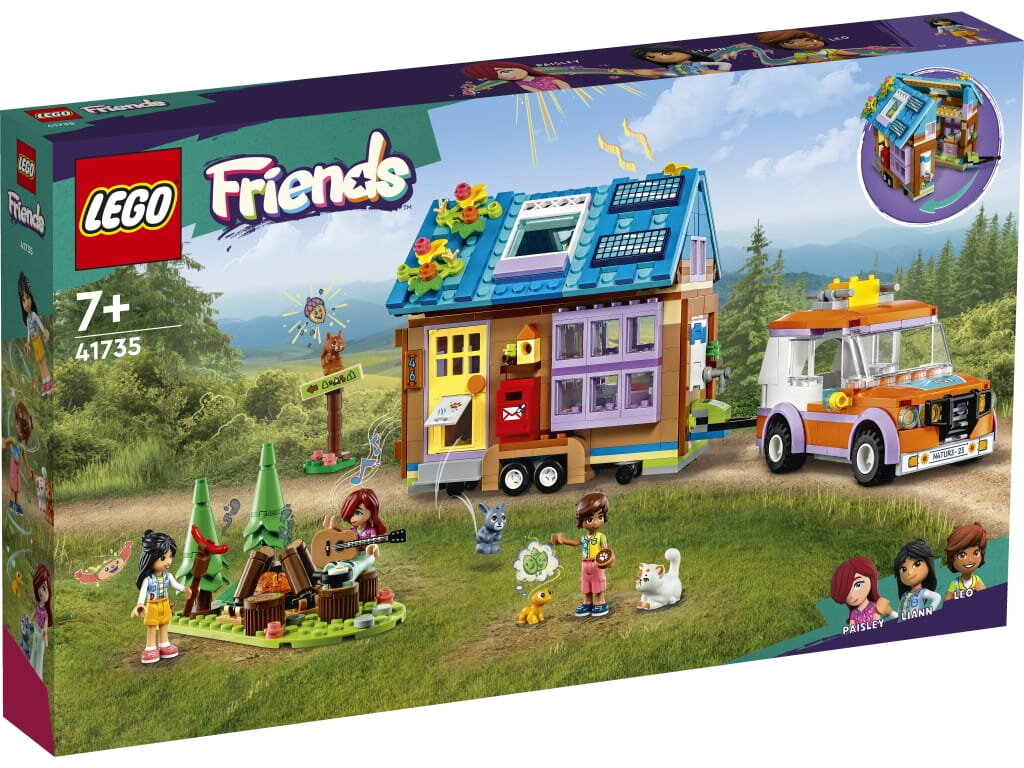 Zestaw Lego Friends z domkiem, samochodem, figurkami i sceną kempingową na zielonej trawie.