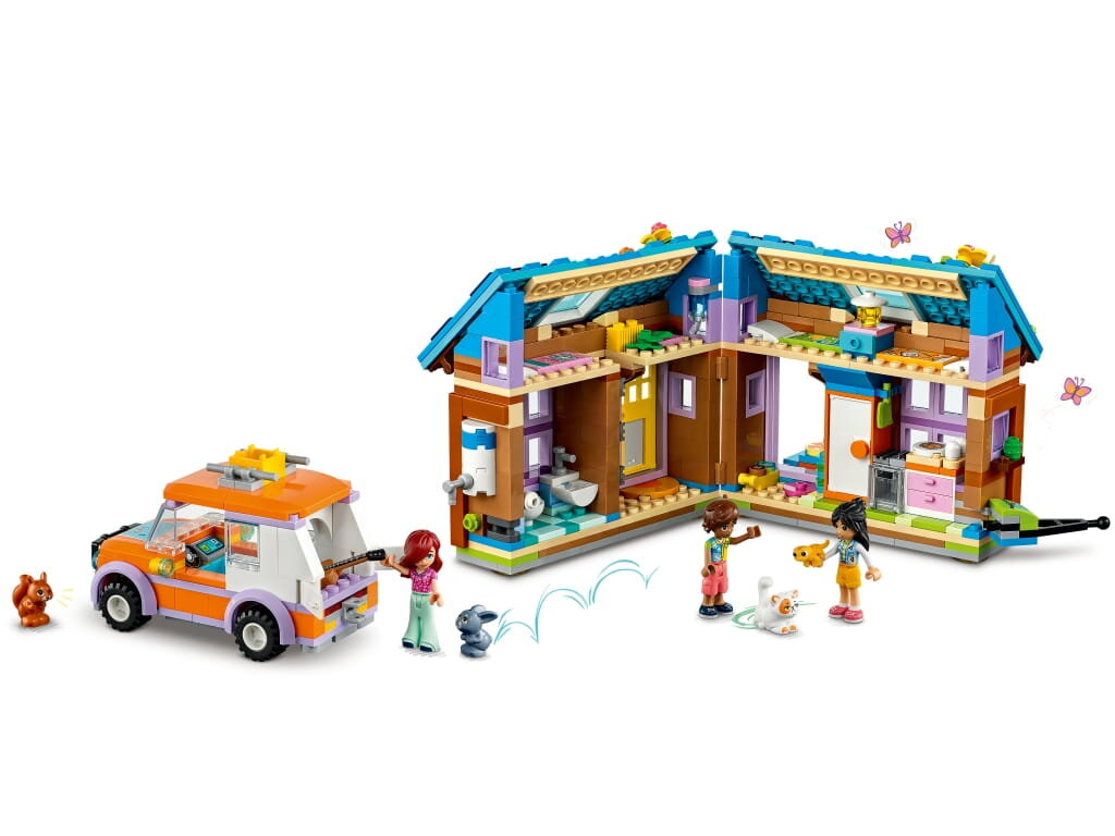 Zestaw Lego Friends z samochodem, domem i trzema postaciami bawiącymi się ze zwierzętami.