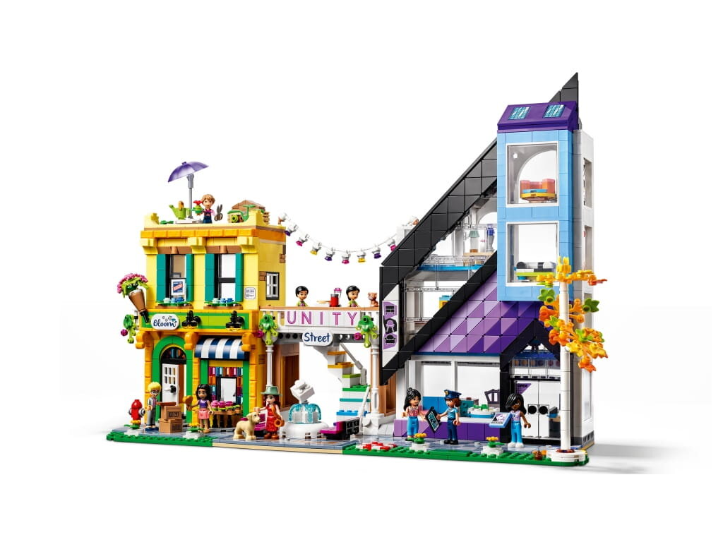Zestaw Lego Friends z kolorowymi budynkami, figurkami i sceną uliczną.