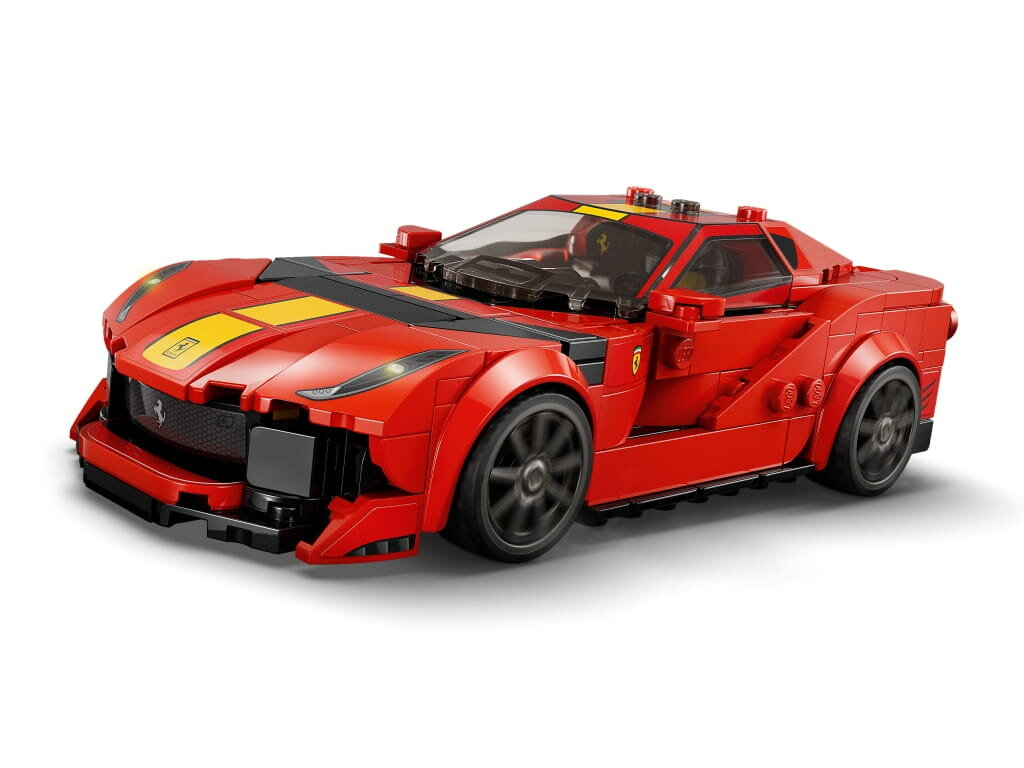Czerwone Lego Ferrari z żółtymi paskami, czarnymi kołami i białym tłem.