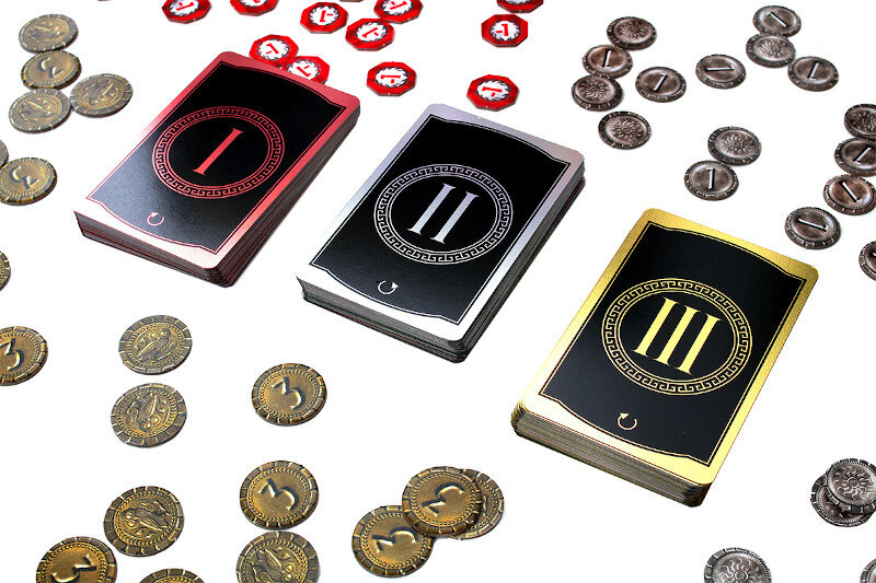 Trzy karty do gry z numerami I, II i III, z rozrzuconymi monetami, białe tło.