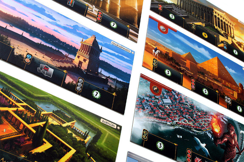 Zbliżenie elementów gry planszowej przedstawiających zabytki. Scena jest pod kątem.