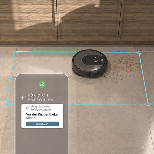 Un aspirateur robot sur un sol, une interface d'application pour smartphone avec une suggestion de nettoyage.