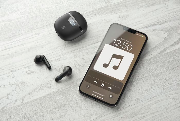 Un téléphone noir affiche une interface d'application musicale, avec des écouteurs et un étui de chargement noirs.
