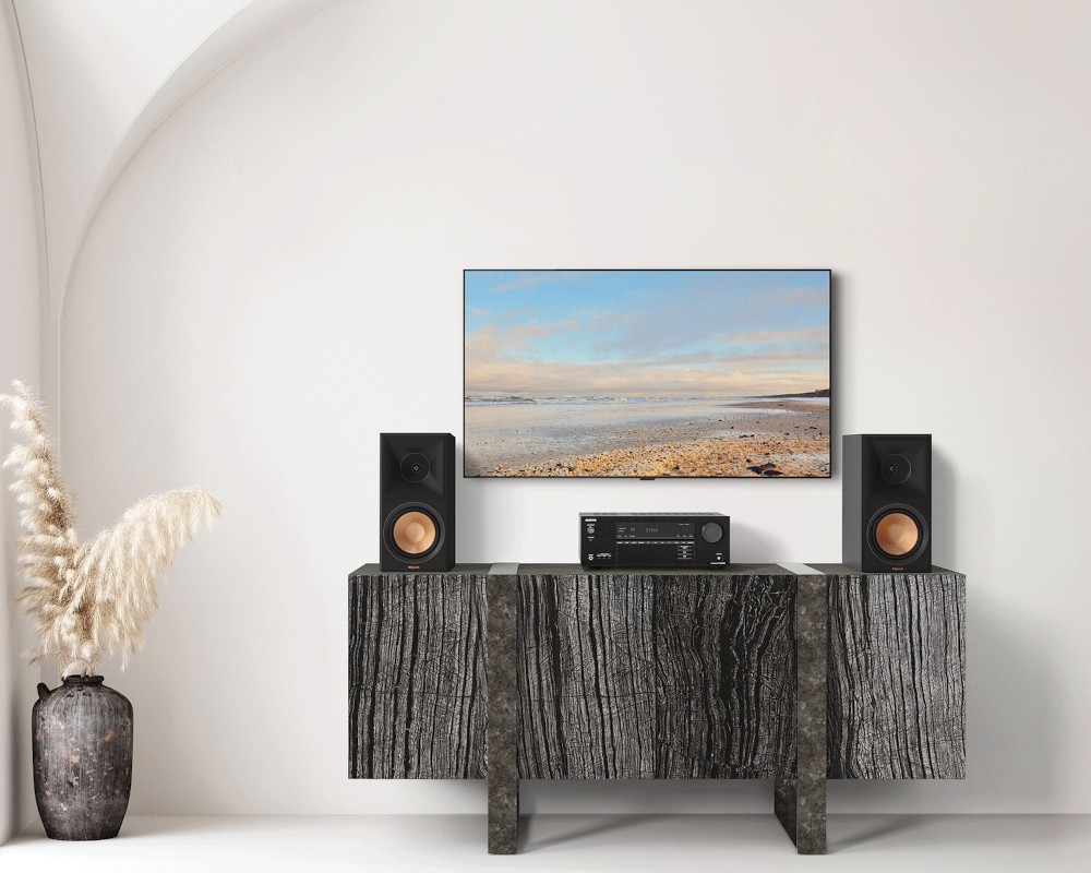 Living room with speakers, TV, and decorative items on a cabinet.
