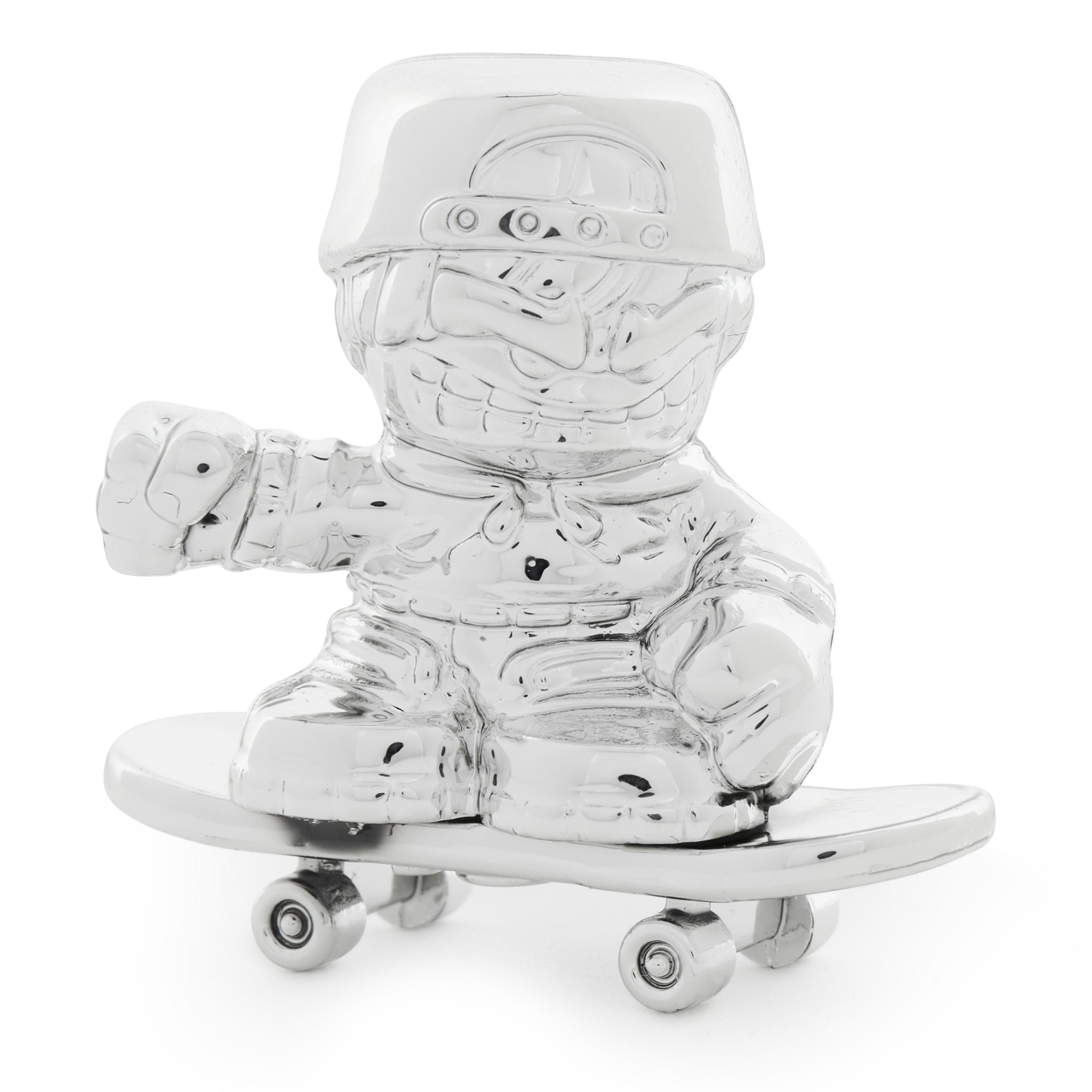 Silbernes Spielzeug eines Jungen auf einem Skateboard, mit Helm, vor weißem Hintergrund.