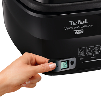 Egy kéz beállítja a digitális kijelzőt egy fekete Tefal Versalio Deluxe készüléken.