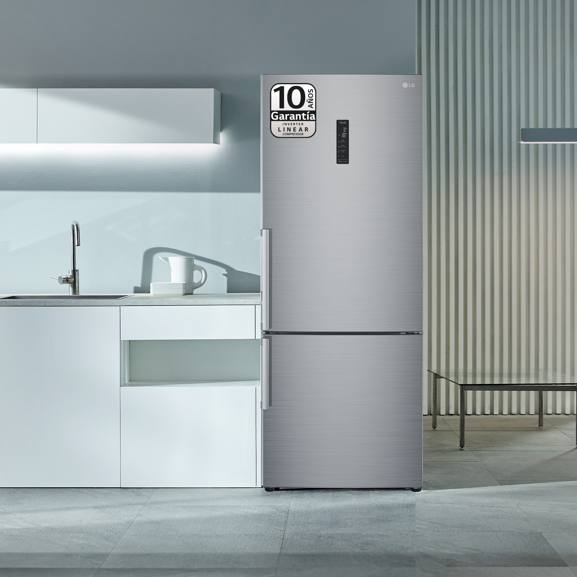 Refrigerador LG plateado en cocina moderna con gabinetes blancos y luz arriba.