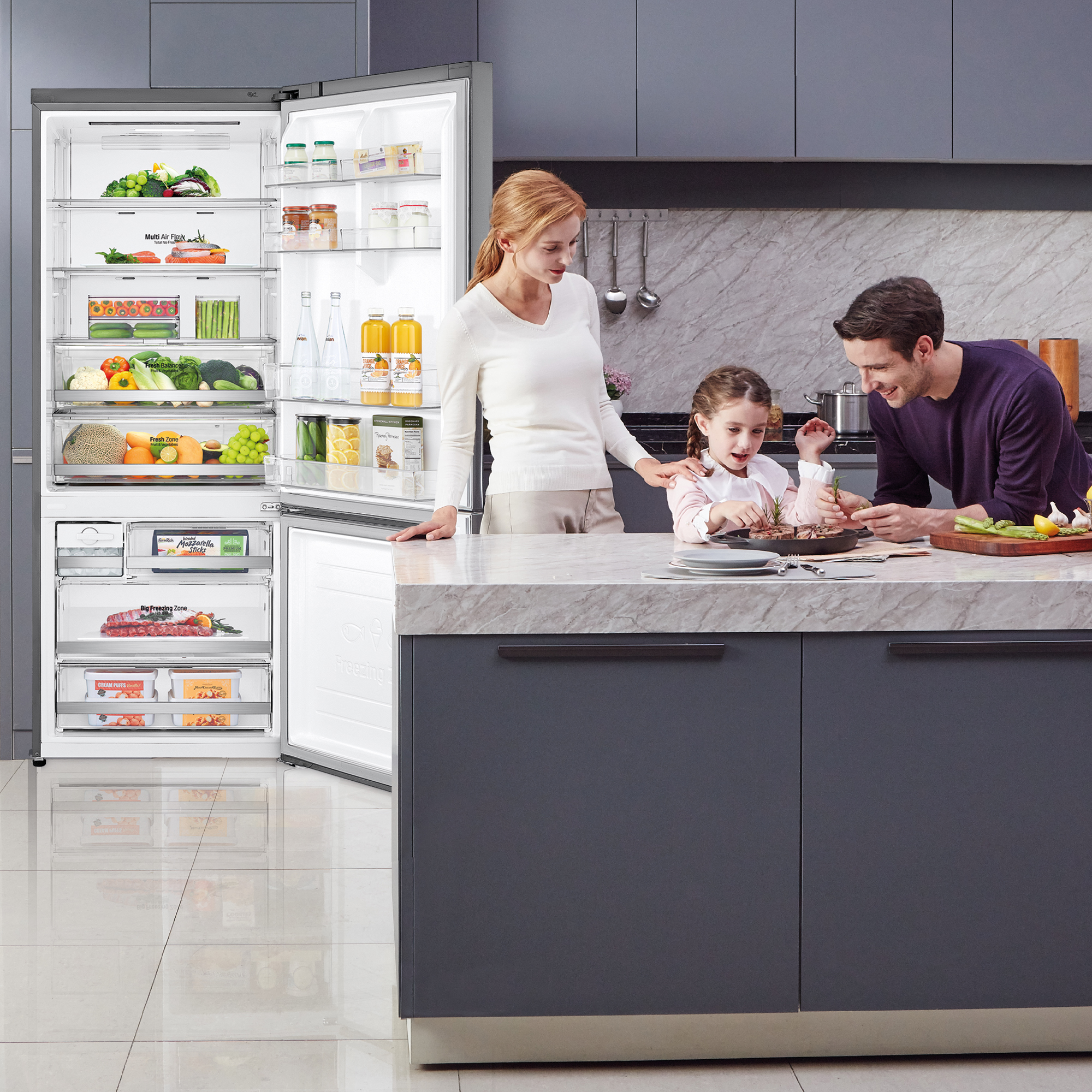 Familia en una cocina con un refrigerador abierto con alimentos.