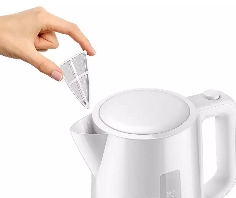 Dłoń trzymająca biały filtr nad białym czajnikiem.