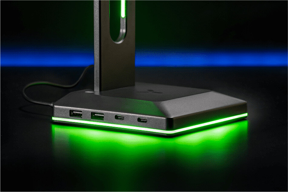 Zbliżenie czarno-szarej podstawki ładującej z zielonym światłem i portami USB.