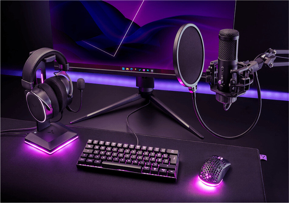 Konfiguracja do gier: słuchawki, mikrofon, klawiatura, mysz i monitor z fioletowym oświetleniem otoczenia.