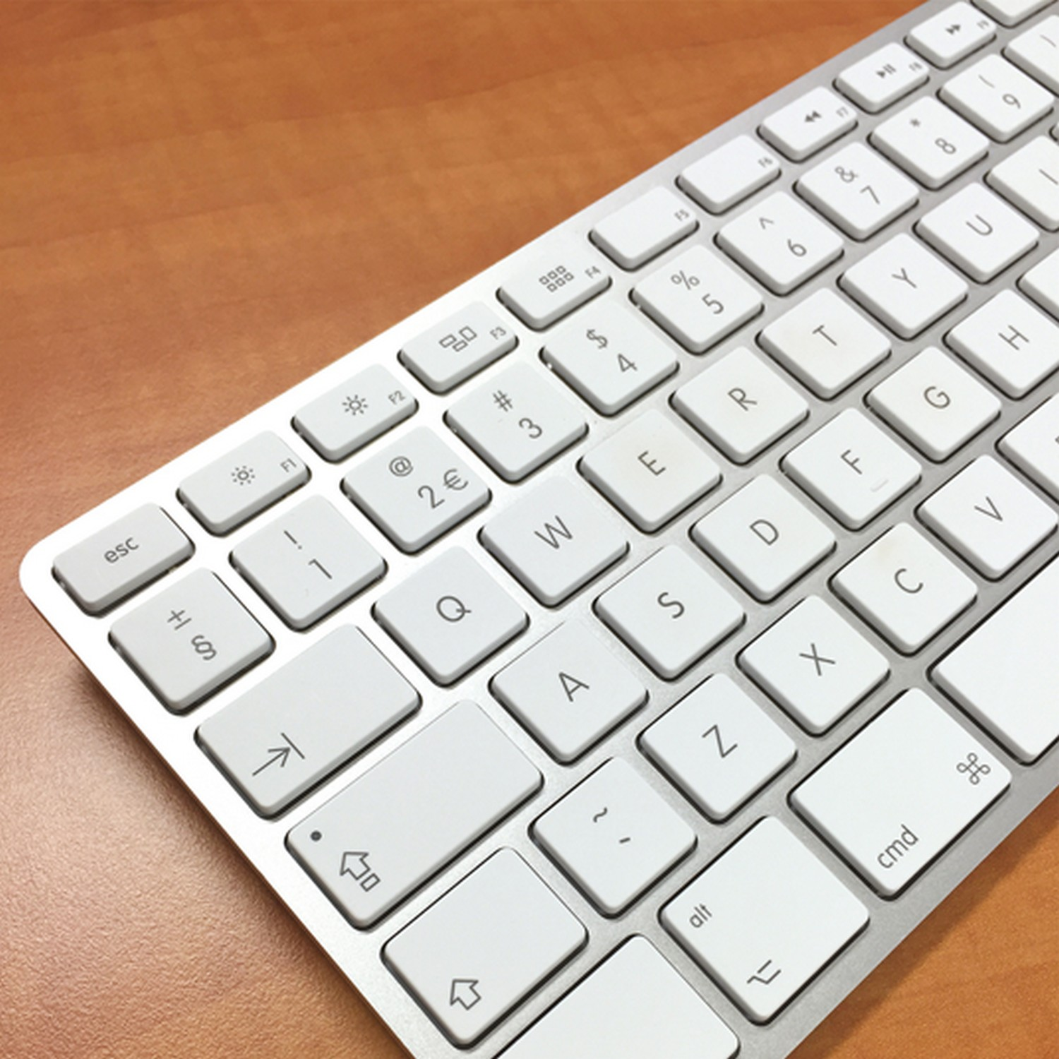 Silver keyboard with white keys. Shows letters, numbers and symbols. Viewed from a top angle.