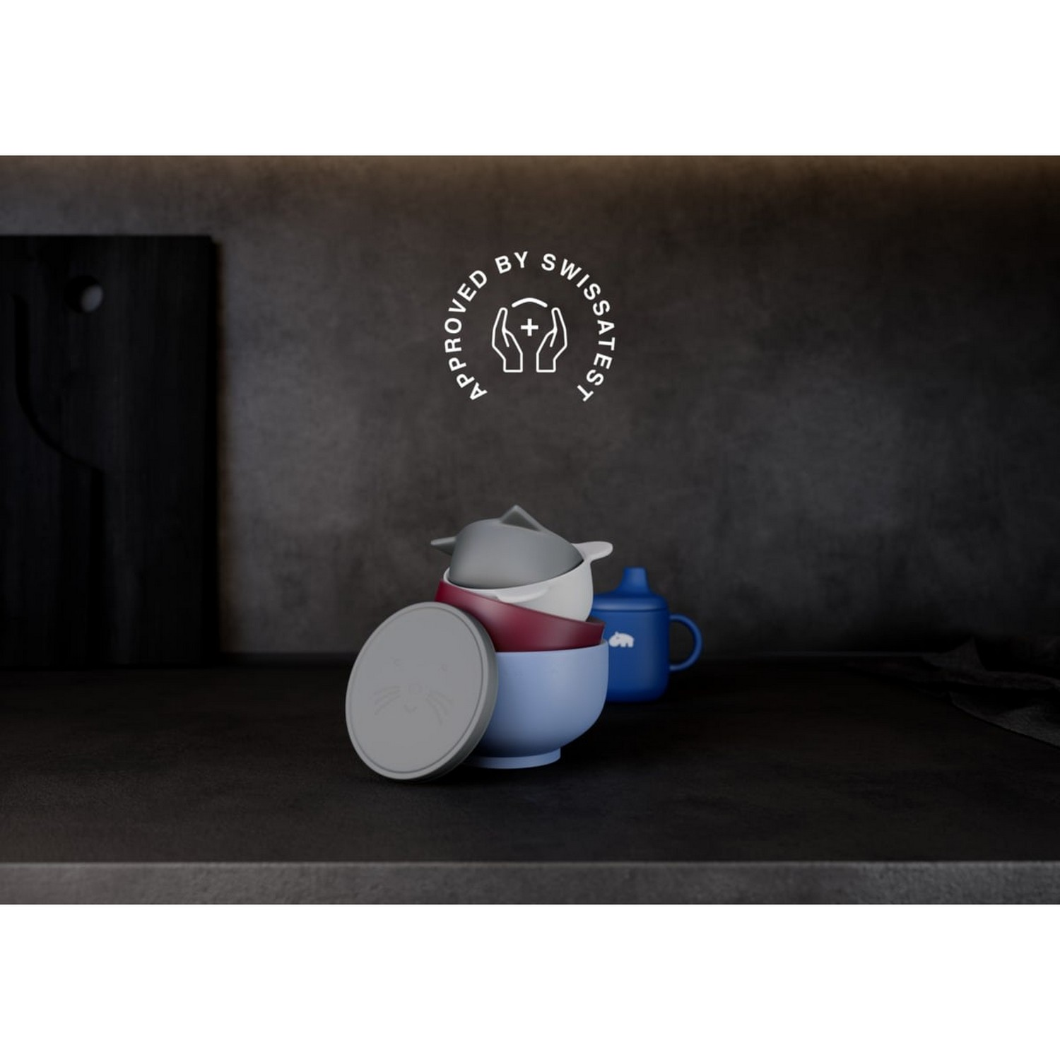 Bowls and a blue cup on a dark surface, approved by Swissatest.