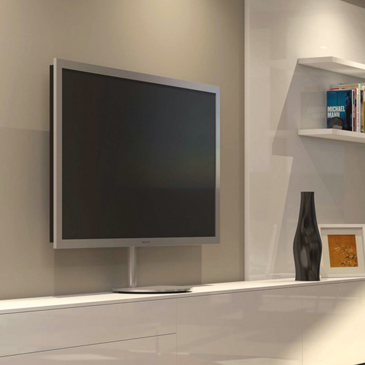 A TV mounted on a wall. It has a silver frame and is above a white cabinet with decor items.