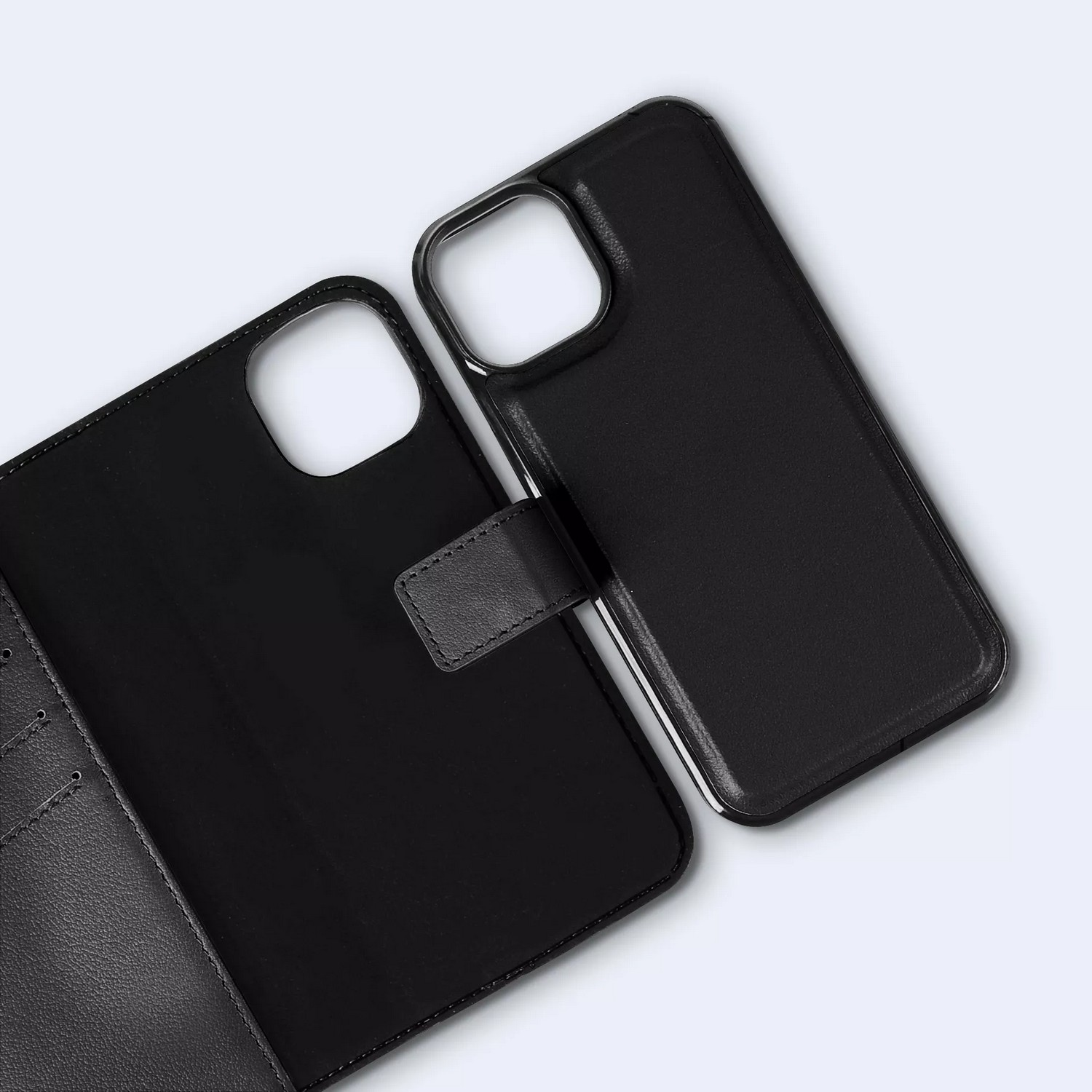 Étui de téléphone noir, ouvert, avec un cadre de téléphone séparé, sur un fond gris clair.