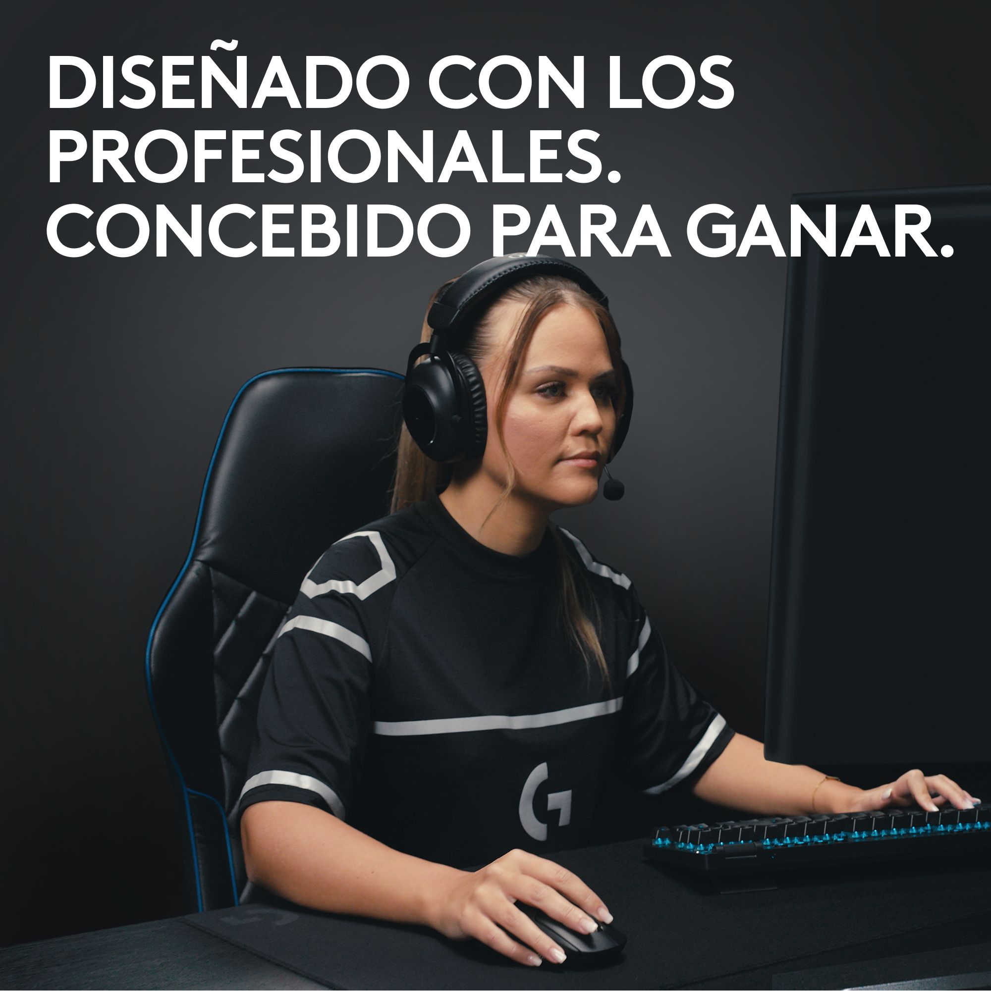 Una mujer con auriculares, sentada en una silla, mirando una pantalla y usando un ratón.