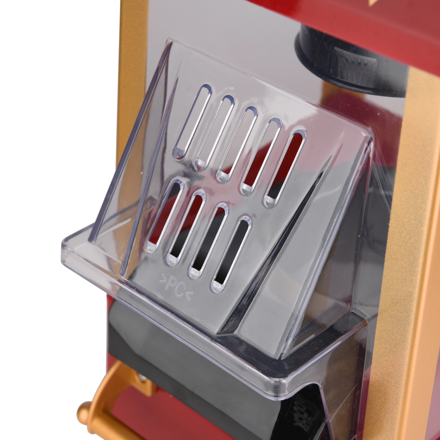 Primer plano de una máquina de palomitas. Compartimento plástico transparente, interior rojo, ribete dorado.