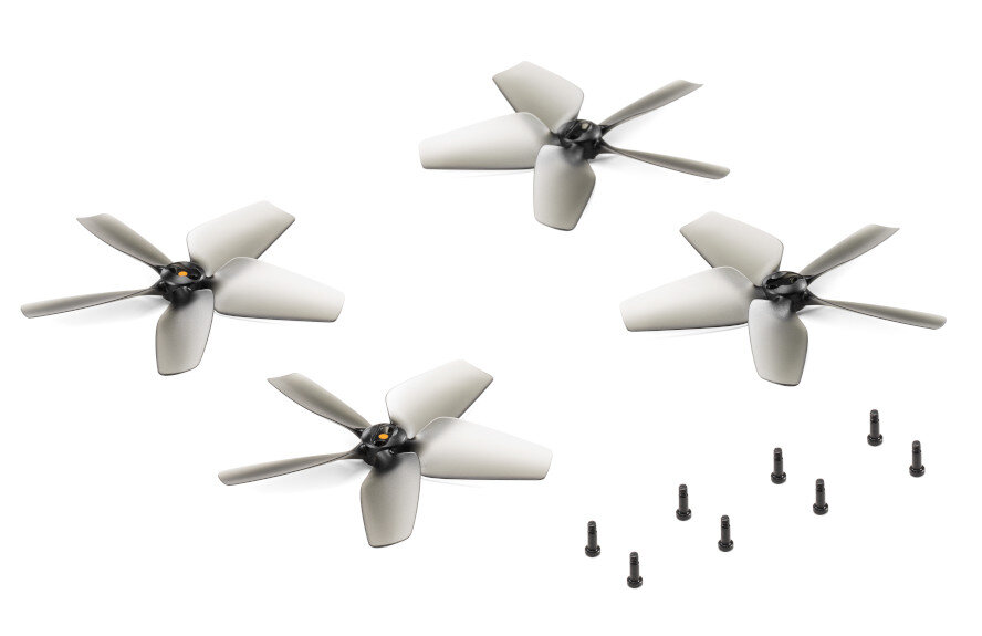 Cztery szare śmigła drona i kilka czarnych śrub na białej powierzchni.